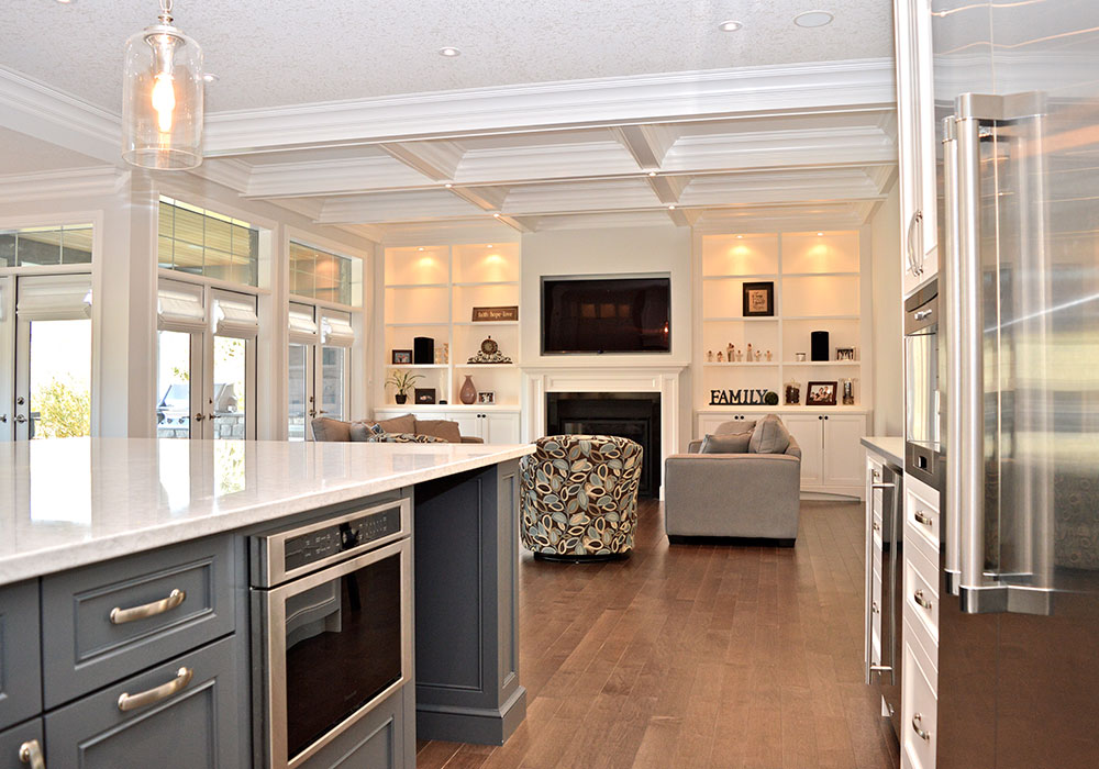 The adjacent family room features custom built-in shelving and coffered ceilings.